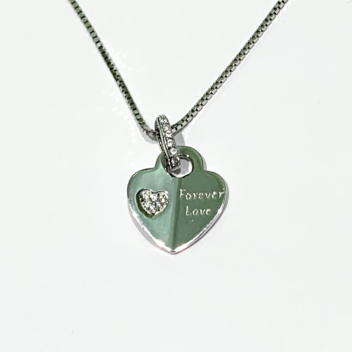 Collana in argento con ciondolo a forma di cuore con incisione interna. Lunghezza catena 42 cm regolabile fino a 44 cm. Dimensioni ciondolo 1,2 cm. Disponibile in due varianti: con scritta "Forever love" con cuoricino ricoperto da zirconi, oppure con scritta "My angel" con un angioletto ricoperto da zirconi. Spedizione gratuita con confezione regalo.