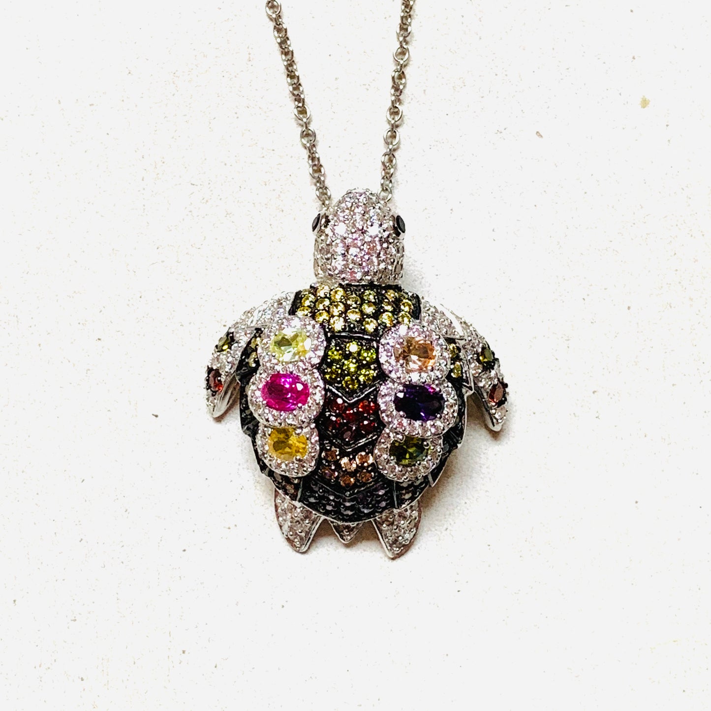 Collana in argento con una tartaruga ricoperta da zirconi multicolore. La catena è impreziosita da piccoli punti luce. Lunghezza catena 42 cm regolabile fino a 44 cm. Dimensioni ciondolo 3 cm di lunghezza x 1 cm di spessore. Spedizione gratuita con confezione regalo.