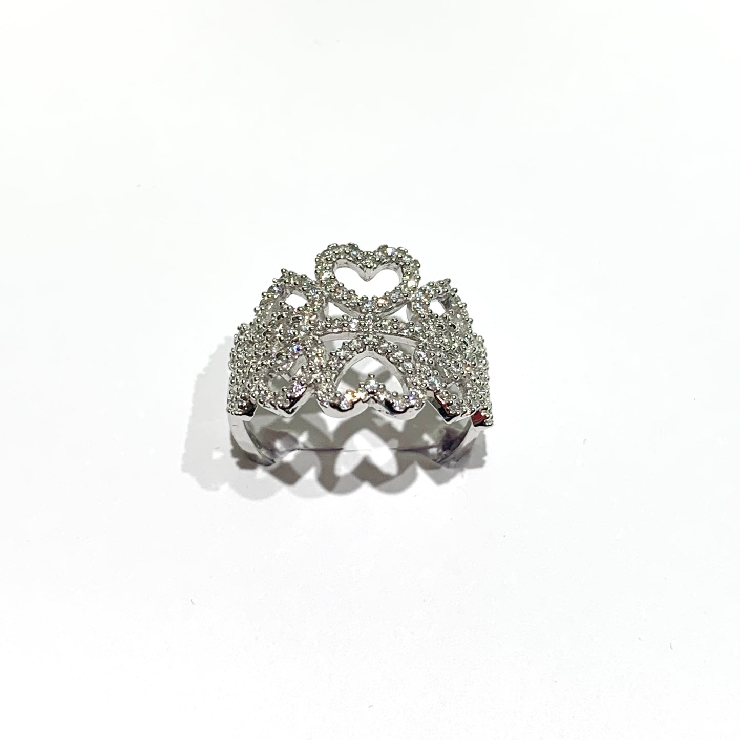 Anello in oro bianco 18kt con fascia impreziosita da cuori ricoperti da zirconi. Larghezza 1,5 cm. Misura 14.