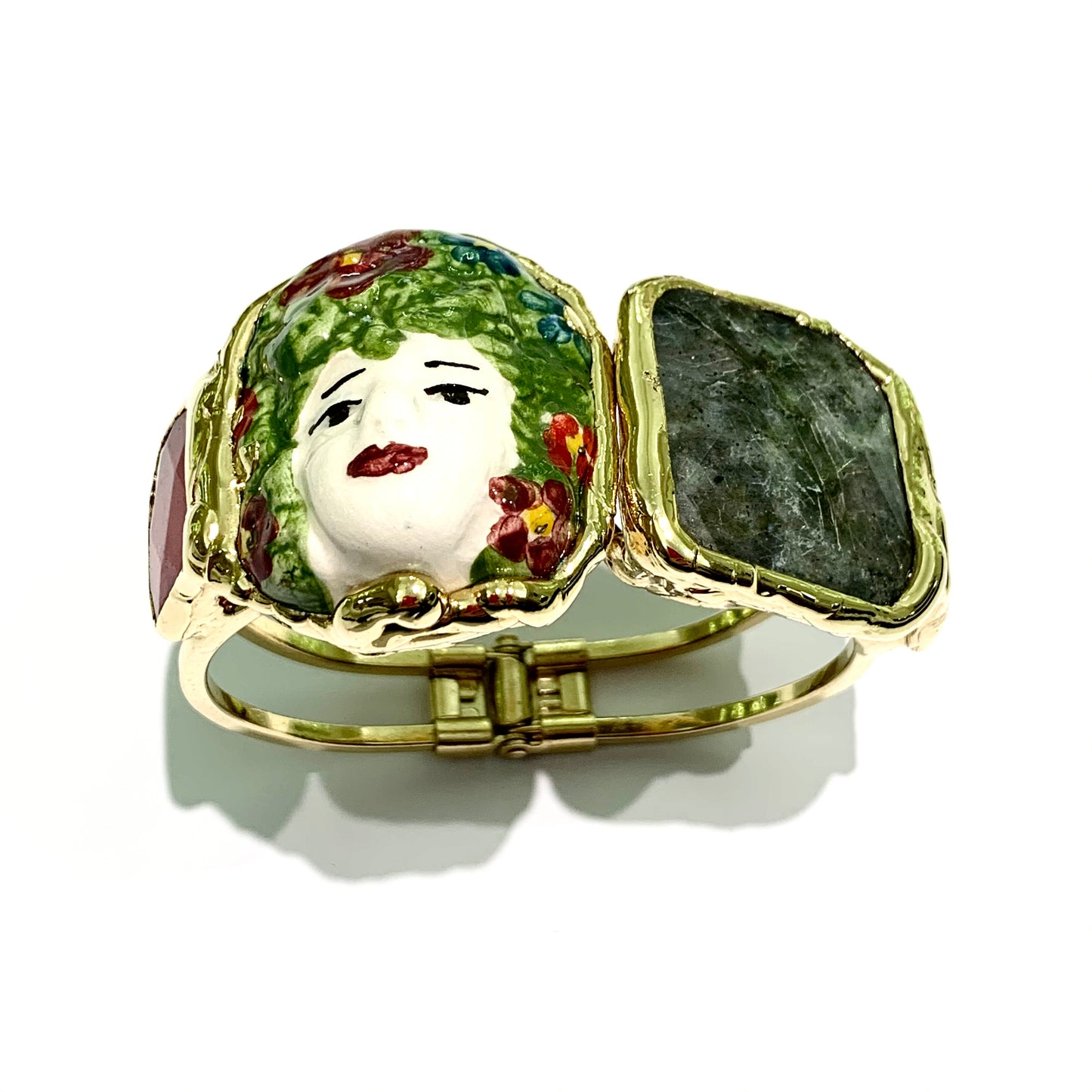 Bracciale rigido in bijoux bagnato in oro giallo con ceramiche di Caltagirone e pietre naturali. Circonferenza bracciale 18 cm, si allarga fino a 2 cm per poterlo indossare. Larghezza ceramiche e pietre da 3 cm a 4 cm. Spedizione gratuita con confezione regalo.