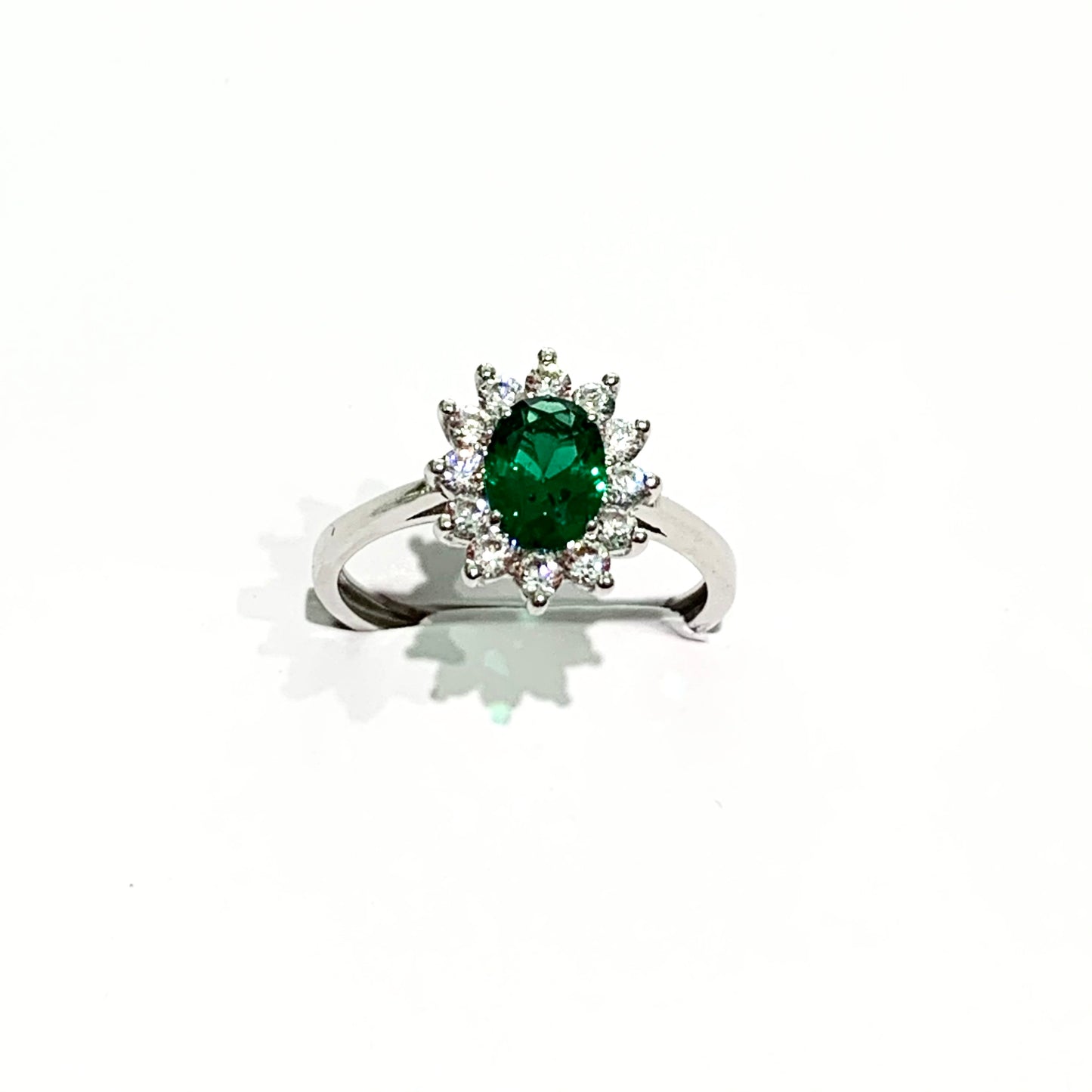 Anello in oro bianco 9kt con zircone ovale colore smeraldo circondato da zirconi bianchi. Dimensione zircone 0,4x0,6 cm. Dimensione totale 0,9x1,1 cm. Misura 12.