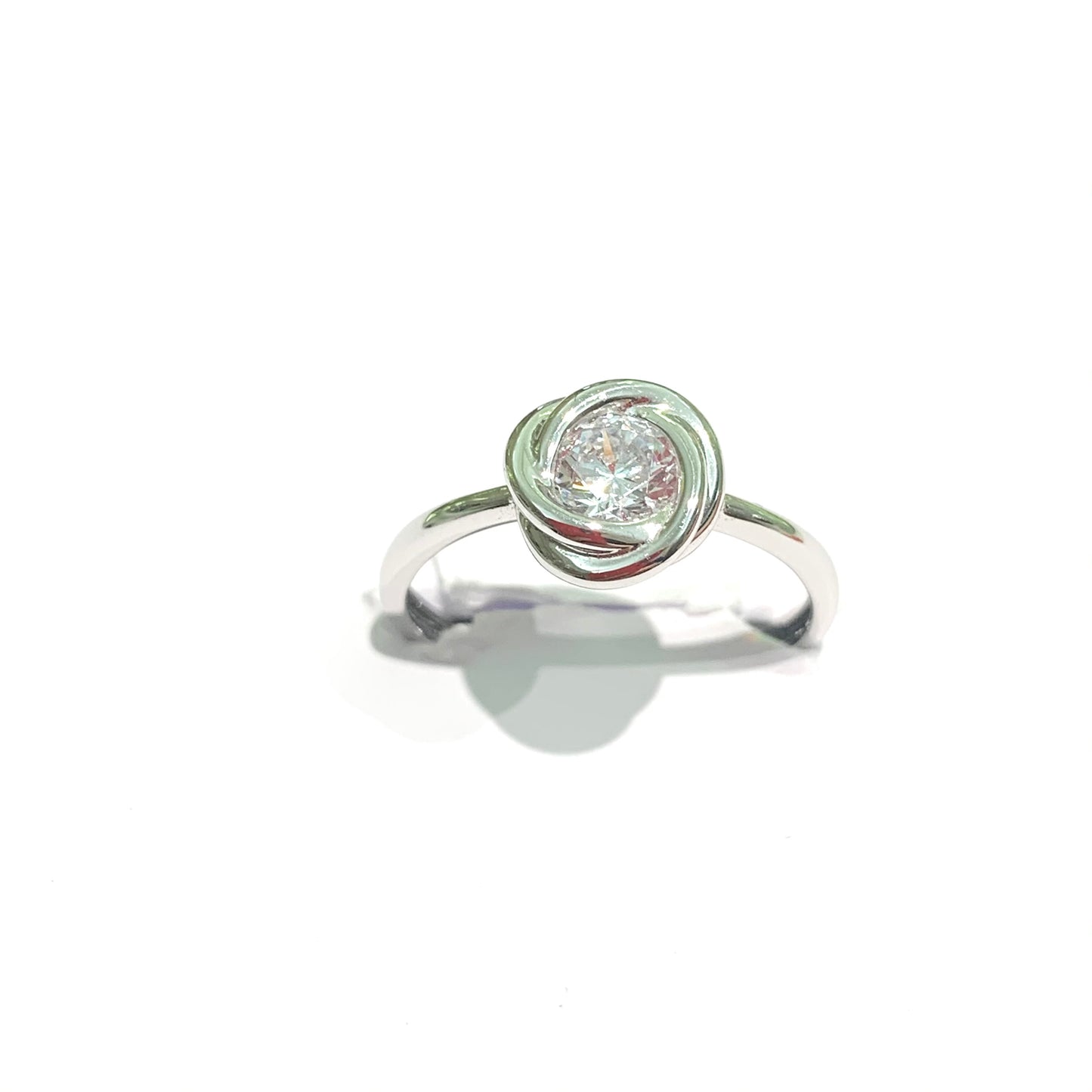 Anello in oro bianco 18kt con nodo e zircone centrale. Dimensione totale 0,8 cm. Misura 13.