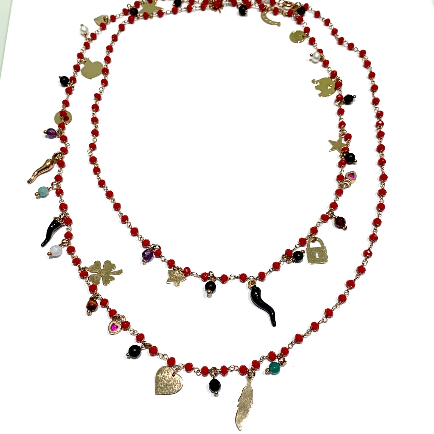 Collana lunga in argento rosa con corallini rossi e pendenti portafortuna. Lunghezza catena 96 cm, con possibilità di indossarla doppia. Ciondoli pendenti di circa 1 cm. Spedizione gratuita con confezione regalo.