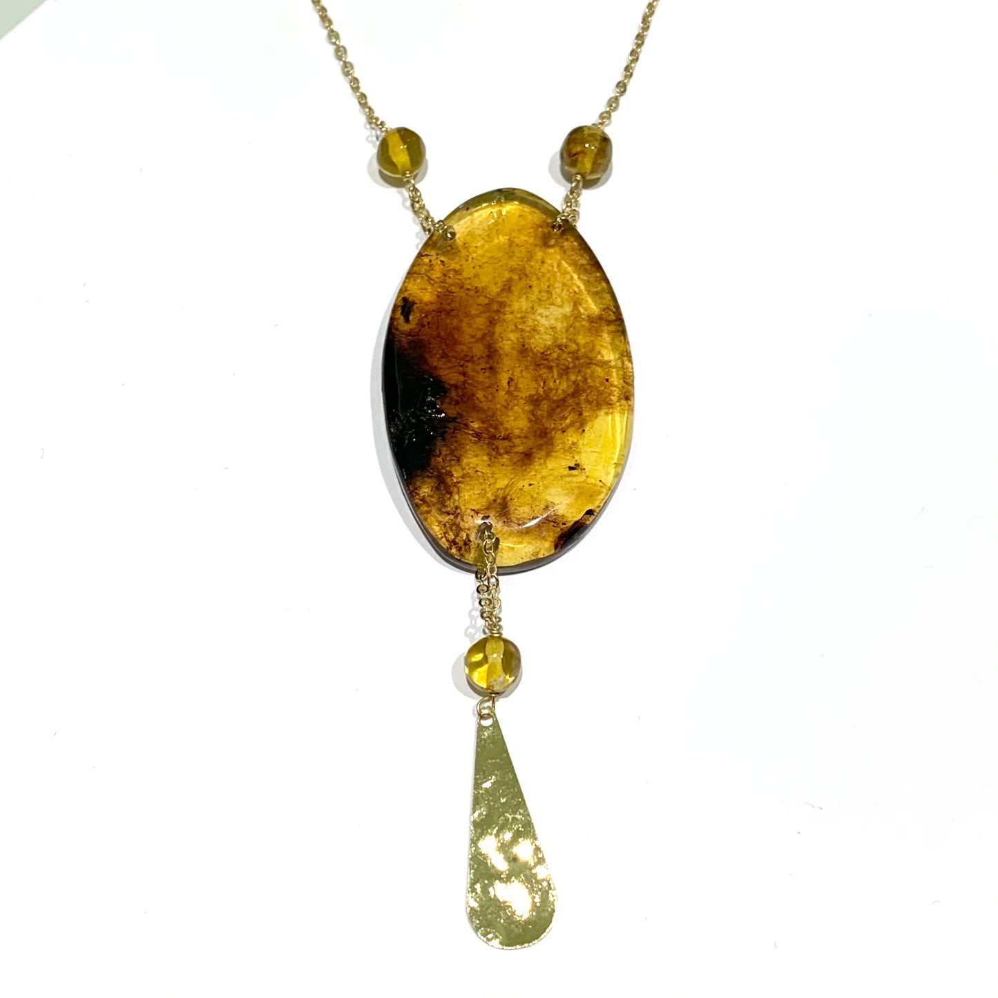 Collana in argento bagnata in oro giallo con ciondolo in Ambra del Chapas (Messico) e goccia dorata pendente. Misure ciondolo 6x3,5 cm. Goccia dorata pendente di lunghezza 3 cm. Spedizione gratuita con confezione regalo.