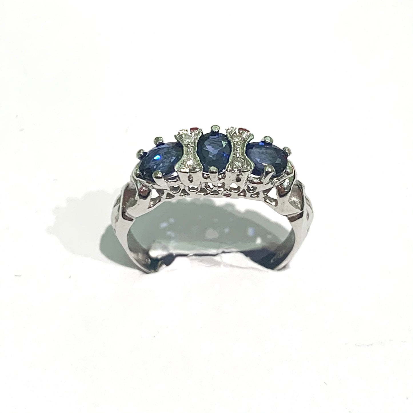 Anello in oro bianco 18kt con diamanti e tre zaffiri centrali. Diamanti 0,18 carati. Dimensione totale 1,5x0,5 cm. Misura 14.