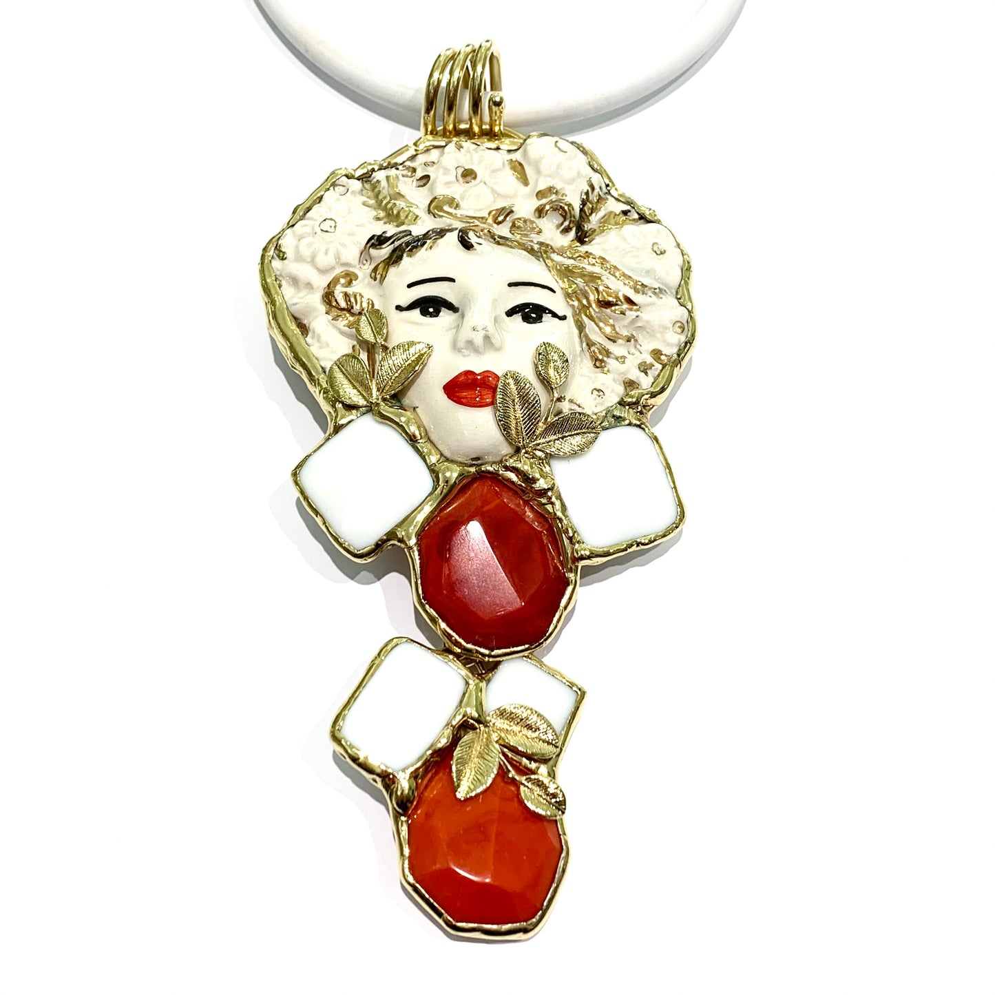 Collana in gomma bianca con ciondolo bagnato in oro con pietre e smalti natutali. Lunghezza catena regolabile da 41 cm a 48 cm di spessore 0,8 cm. Lunghezza ciondolo viso 14 cm incluso anellino. Lunghezza ciondolo inferiore 6 cm. Possibilità di togliere ciondolo inferiore. Spedizione gratuita con confezione regalo.