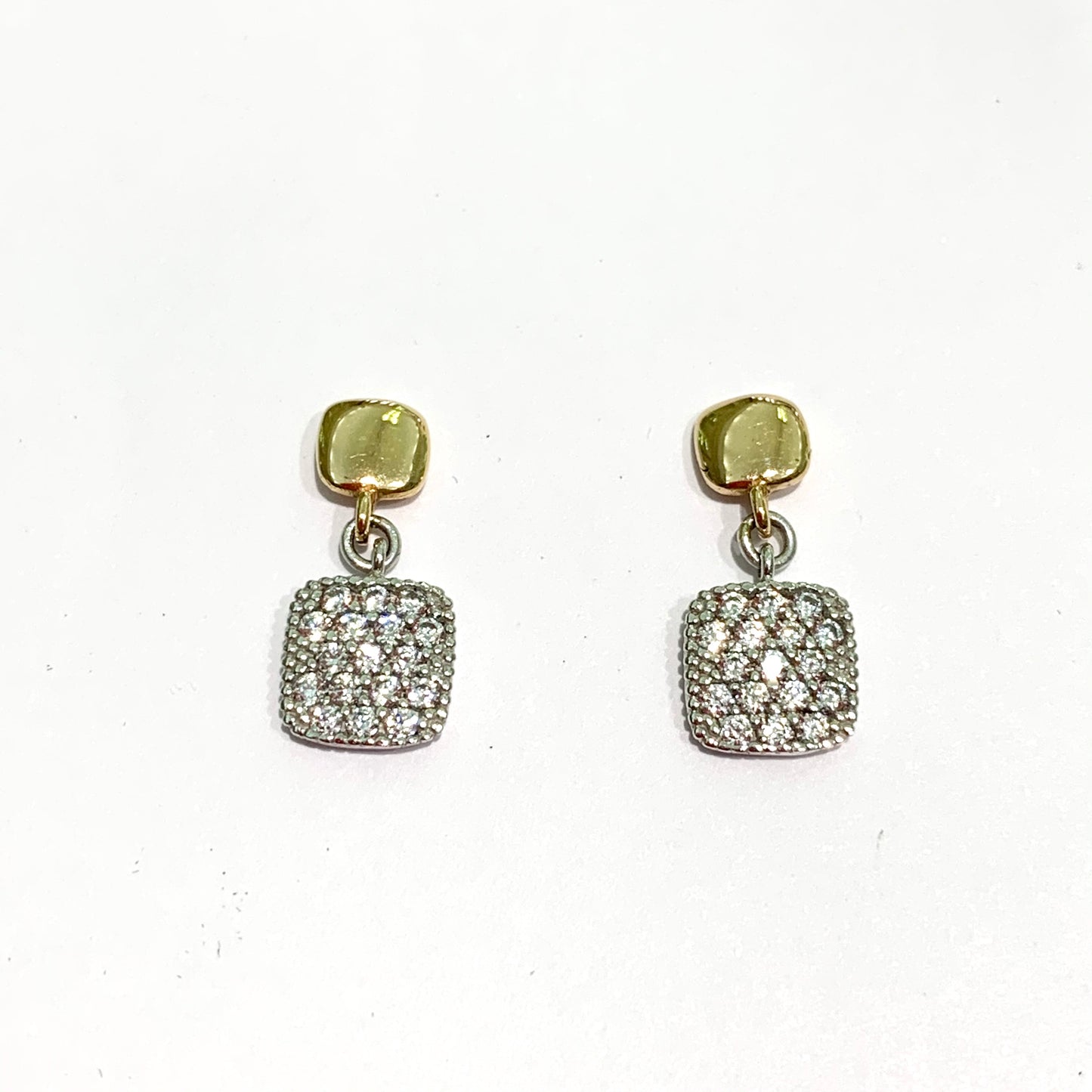 Orecchini in oro rosa 18kt con quadrati pendenti ricoperti da zirconi. Lunghezza totale 1,5 cm, di cui 0,5 cm il quadrato. Chiusura con farfalline. Spedizione gratuita con confezione regalo.