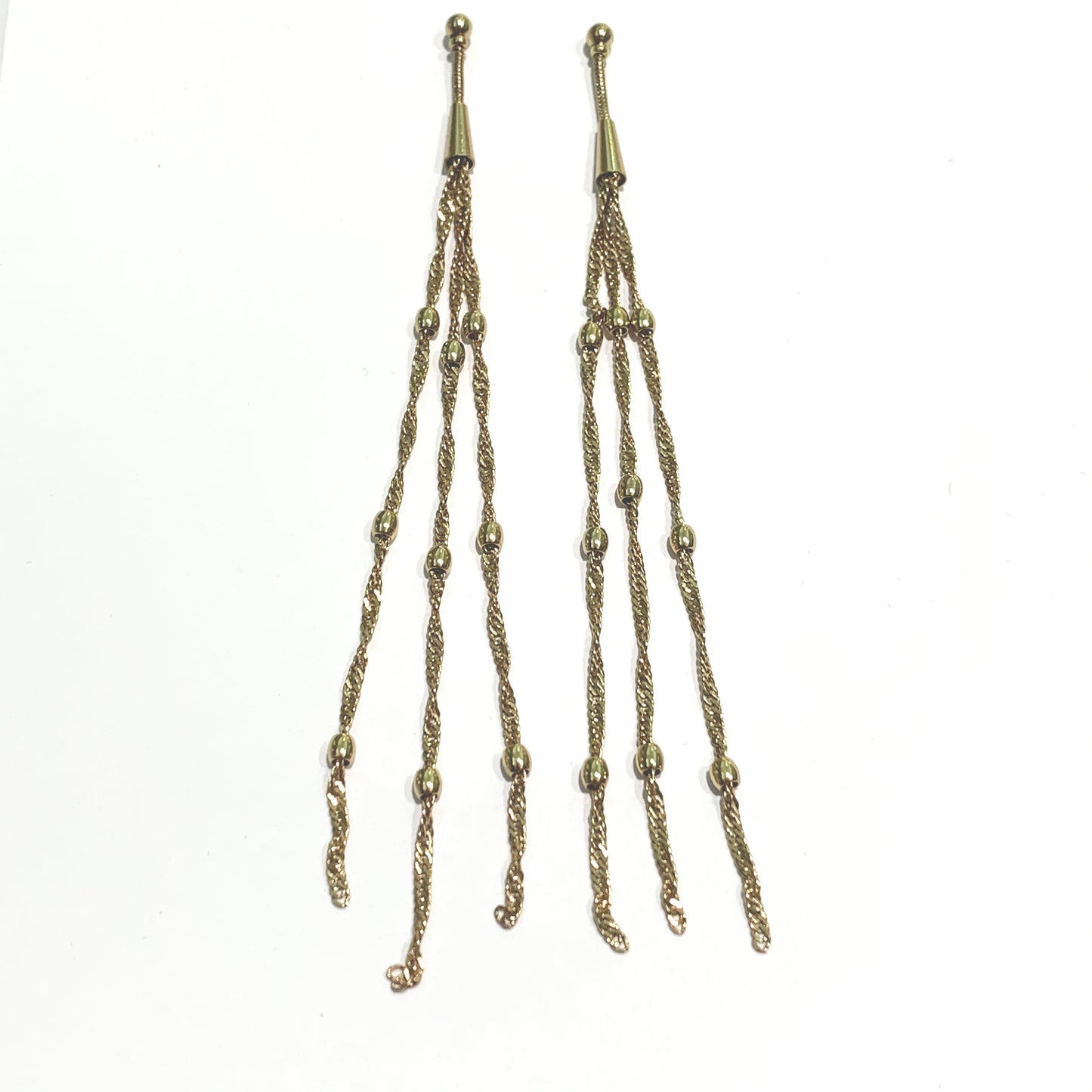 Orecchini pendenti in bijoux bagnati in oro giallo con tre fili pendenti. Lunghezza 13 cm. Spessore filo 0,2 cm. Chiusura con farfalline. Spedizione gratuita con confezione regalo.