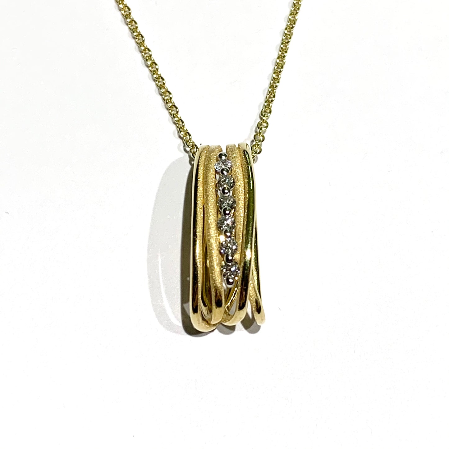 Collana in oro giallo 18kt con barretta verticale impreziosita da un filo di diamanti nella parte centrale. Marchio Annamaria Cammilli. Lunghezza catena 42 cm. Caratura diamanti 0,12. Dimensione ciondolo 1,5x0,5 cm. Spedizione gratuita con confezione regalo.
