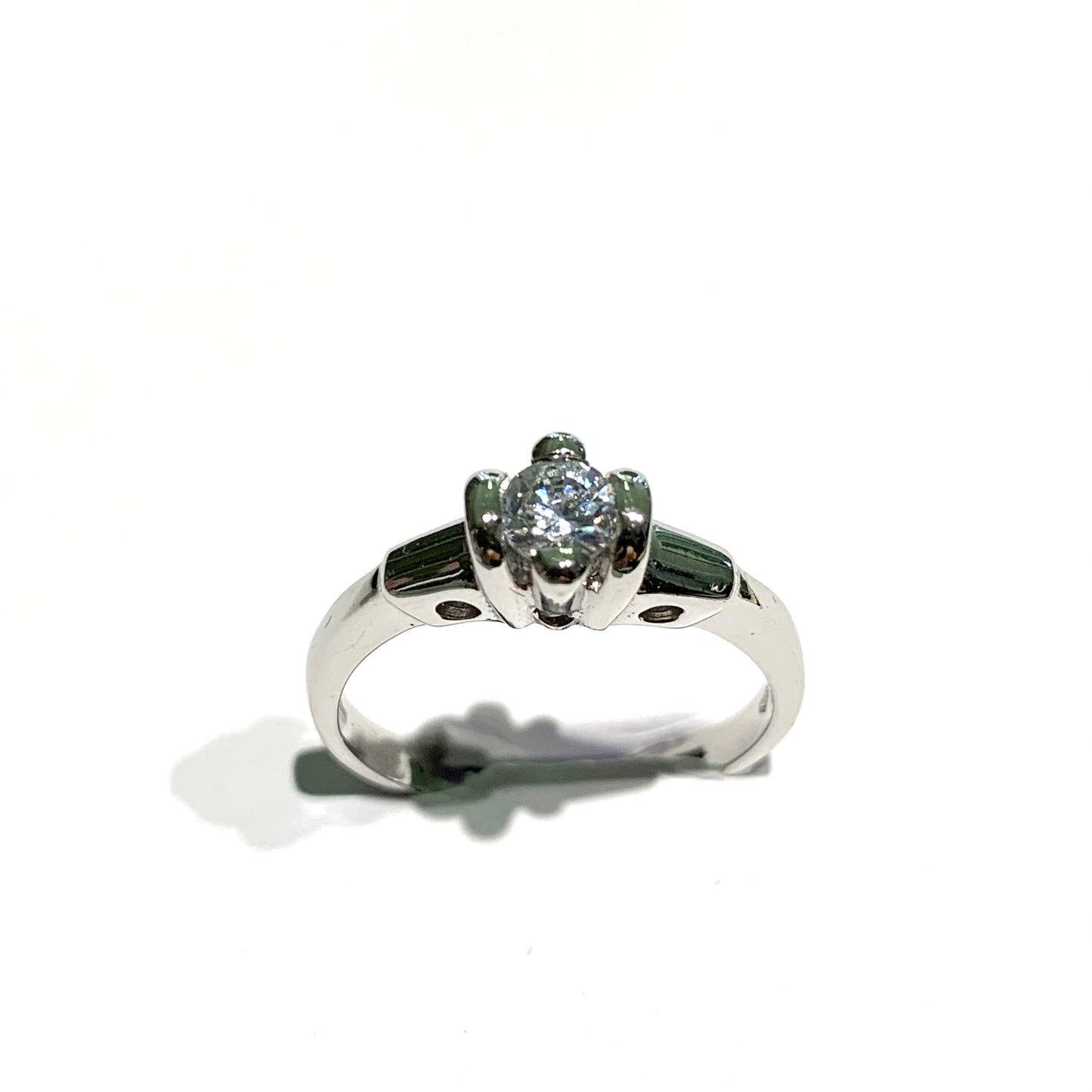 Anello solitario in oro bianco 18kt con zircone tondo fermato da quattro griffes larghe. Dimensione zircone 0,4 cm. Misura 16.