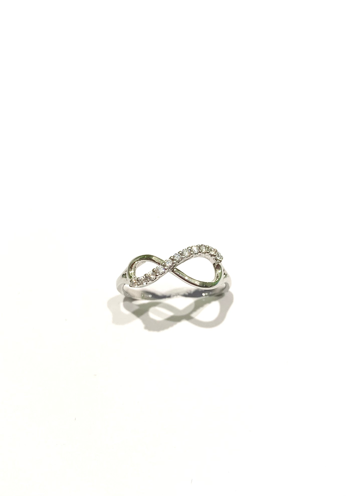Anello in oro bianco 18kt con l'infinito ricoperto in parte da zirconi. Dimensione infinito 0,7 cm nella parte più ampia, 0,5 cm nella parte più stretta. Misura 14.