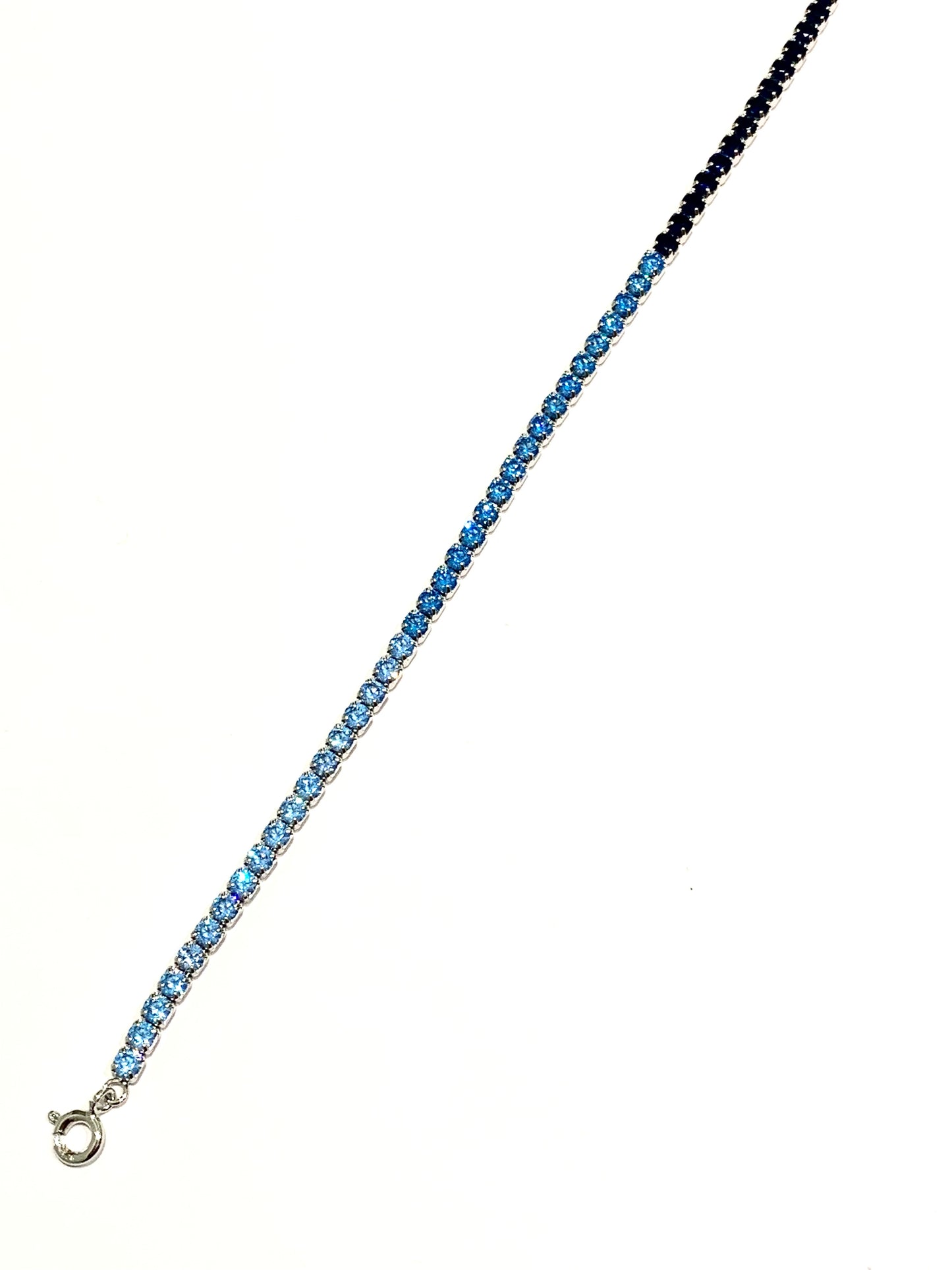 Bracciale tennis in argento con zirconi di colore azzurro e blu. Lunghezza regolabile da 17,5 a 21 cm. Dimensione zirconi 0,3 cm.