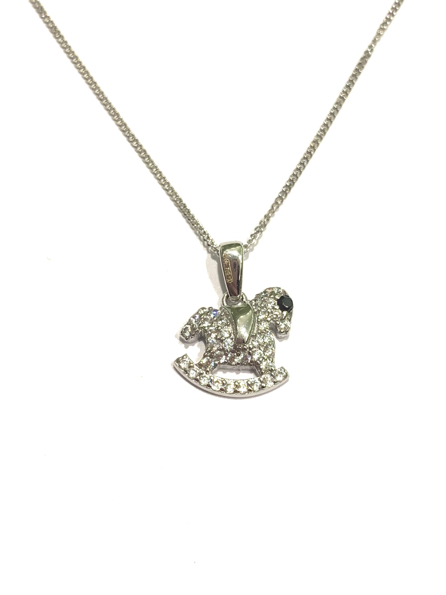 Collana in oro bianco 9kt con cavallo a dondolo ricoperto interamente da zirconi bianchi e con l’occhietto impreziosito da uno zircone nero. Lunghezza catena 45 cm. Dimensioni ciondolo 1,3 cm incluso anellino.