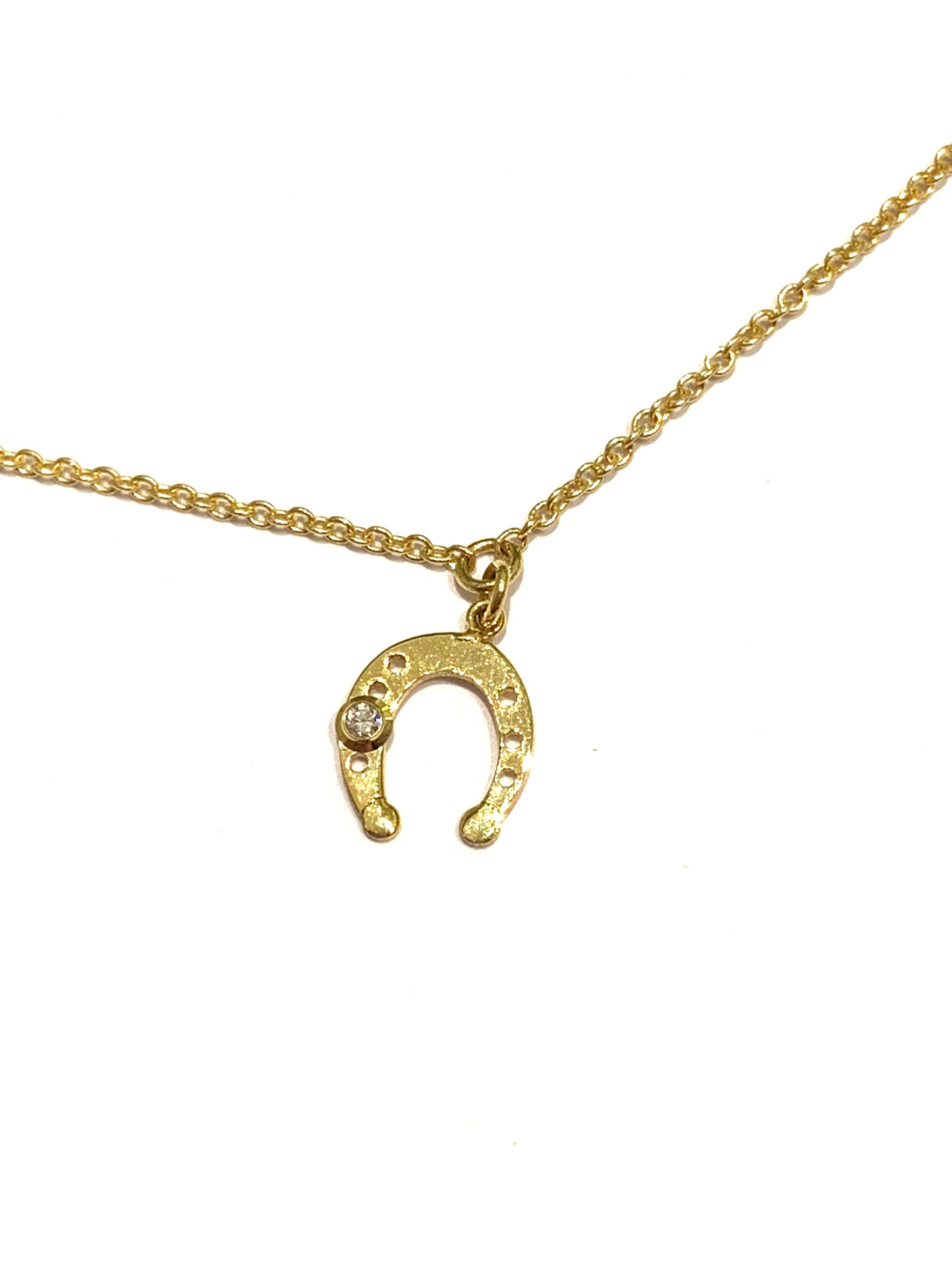 Bracciale in oro giallo 18kt con ferro di cavallo e piccolo diamantino di 0,01 carati. Lunghezza regolabile da 17 a 19 cm. Dimensione ferro di cavallo 0,7 cm.