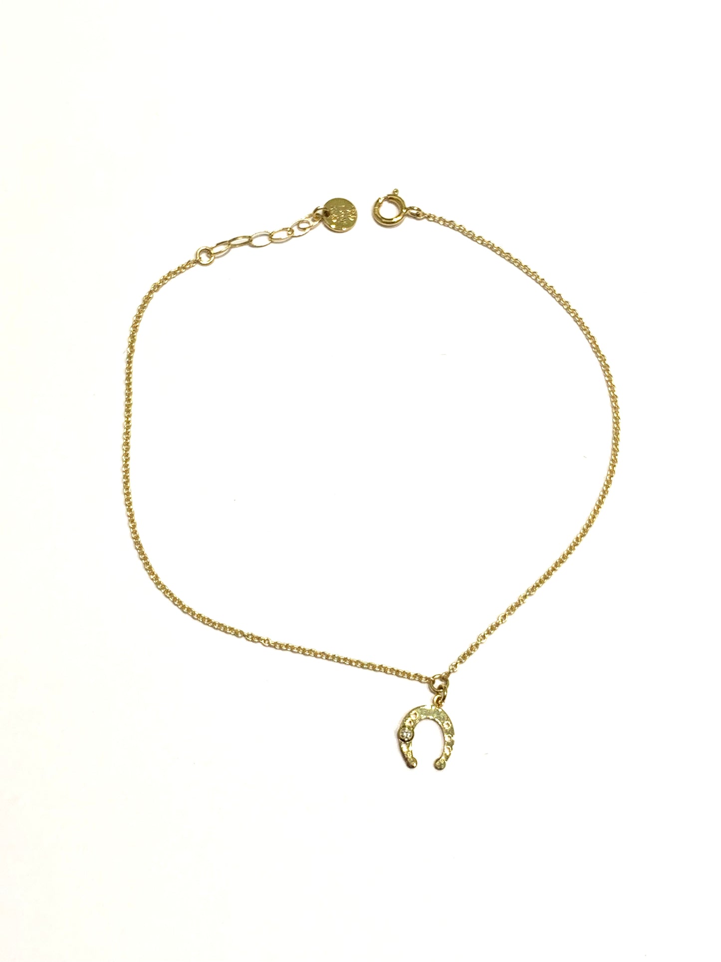 Bracciale in oro giallo 18kt con ferro di cavallo e piccolo diamantino di 0,01 carati. Lunghezza regolabile da 17 a 19 cm. Dimensione ferro di cavallo 0,7 cm.