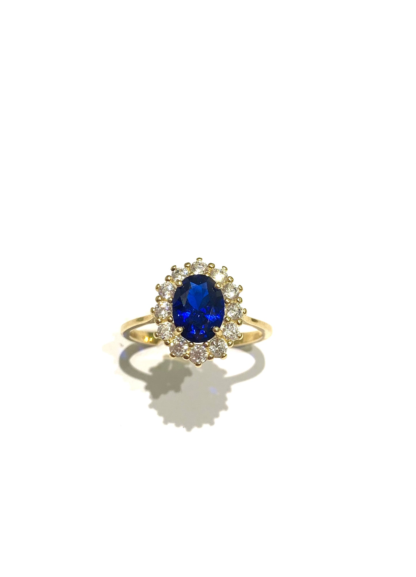 Anello in oro giallo 9kt con zircone colore zaffiro circondati da zirconi bianchi. Dimensione zircone colore zaffiro 0,8x0,5 cm. Dimensione totale 1x1,2cm. Misura 13.