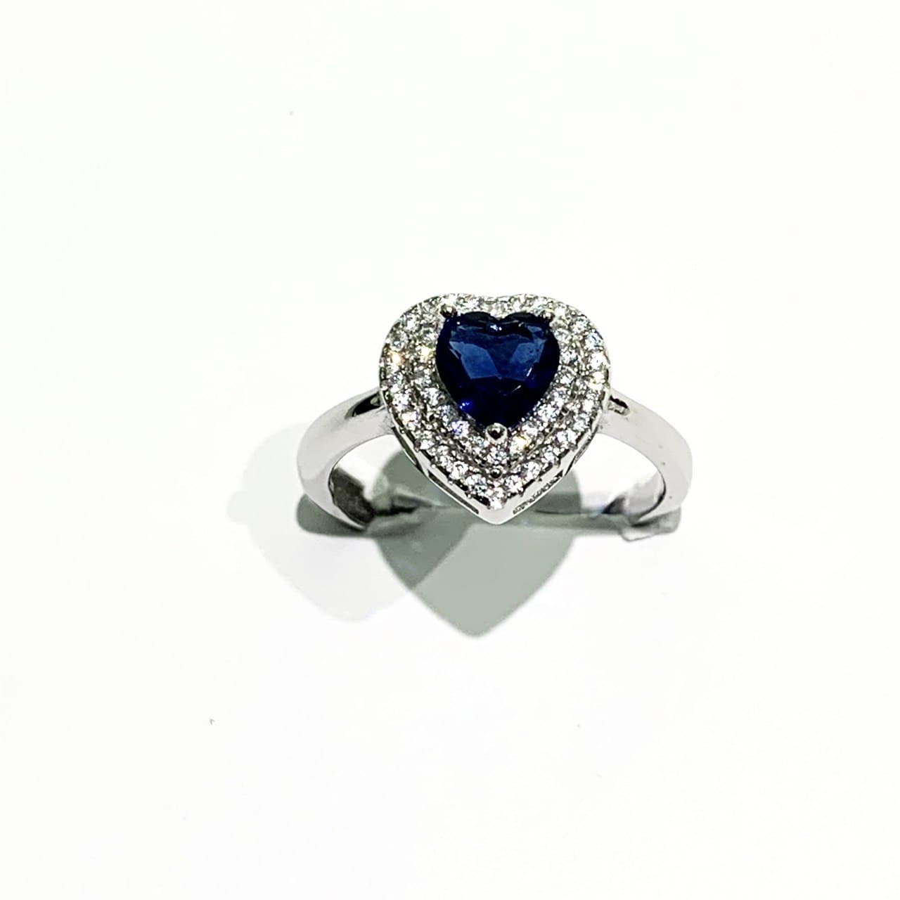 Anello in argento con zircone a forma di cuore circondato da due giri di zirconi bianchi.