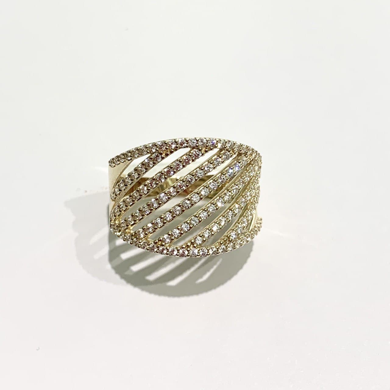 Anello a fascia in oro giallo 18kt ricoperto da zirconi in diagonale. Larghezza 1,5 cm nella parte centrale e 1 cm ai lati. Misura 16. Spedizione gratuita con confezione regalo.