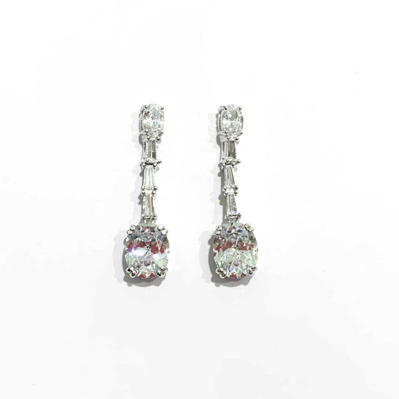 Orecchini in argento con barretta e zirconi pendenti. Lunghezza 3 cm. Larghezza zircone più grande 0,7 cm. Larghezza barretta 0,2 cm. Spedizione gratuita con confezione regalo.