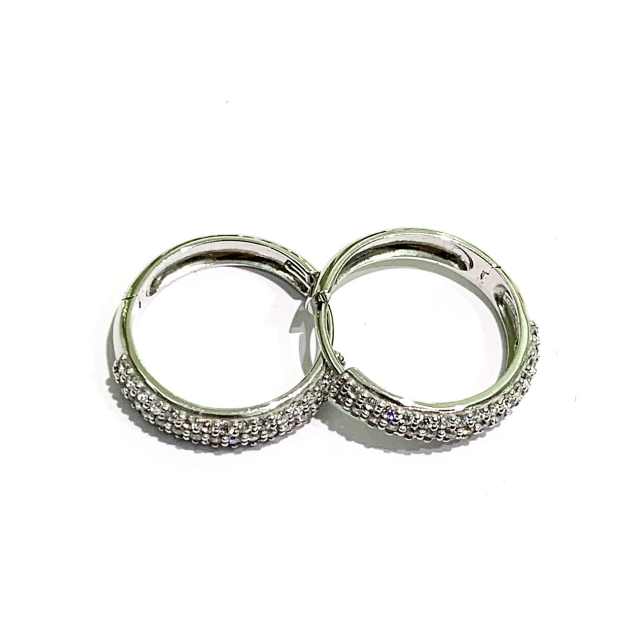 Orecchini in oro bianco 18kt ricoperti da zirconi bianchi. Diametro interno 1,3 cm. Spessore 0,3 cm. Chiusura a scatto.