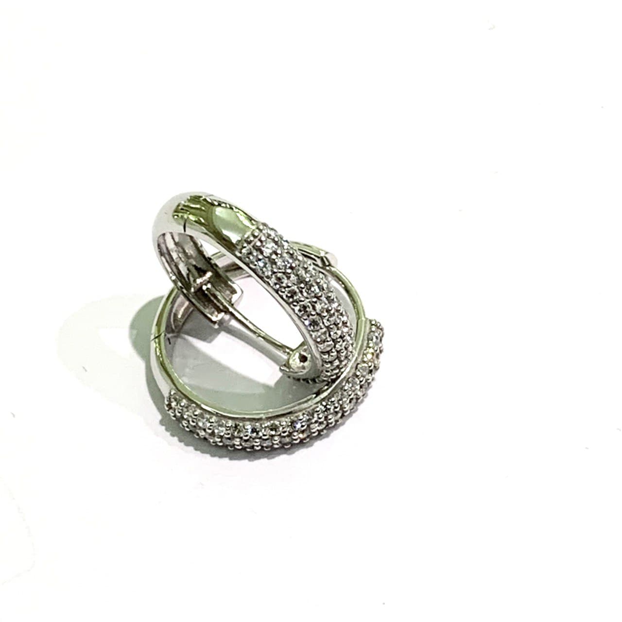 Orecchini in oro bianco 18kt ricoperti da zirconi bianchi. Diametro interno 1,3 cm. Spessore 0,3 cm. Chiusura a scatto.