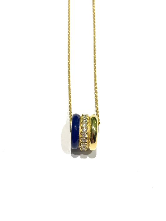 Collana in argento bagnata in oro giallo con ciondolo tondo. Esso é caratterizzato da tre strisce, di cui una smaltata blu, una impreziosita interamente da zirconi e una liscia in argento dorato.
Lunghezza catena regolabile a 40 cm oppure a 45 cm.
Dimensione ciondolo 1,3x1 cm.
Diametro interno del ciondolo 0,6 cm.
