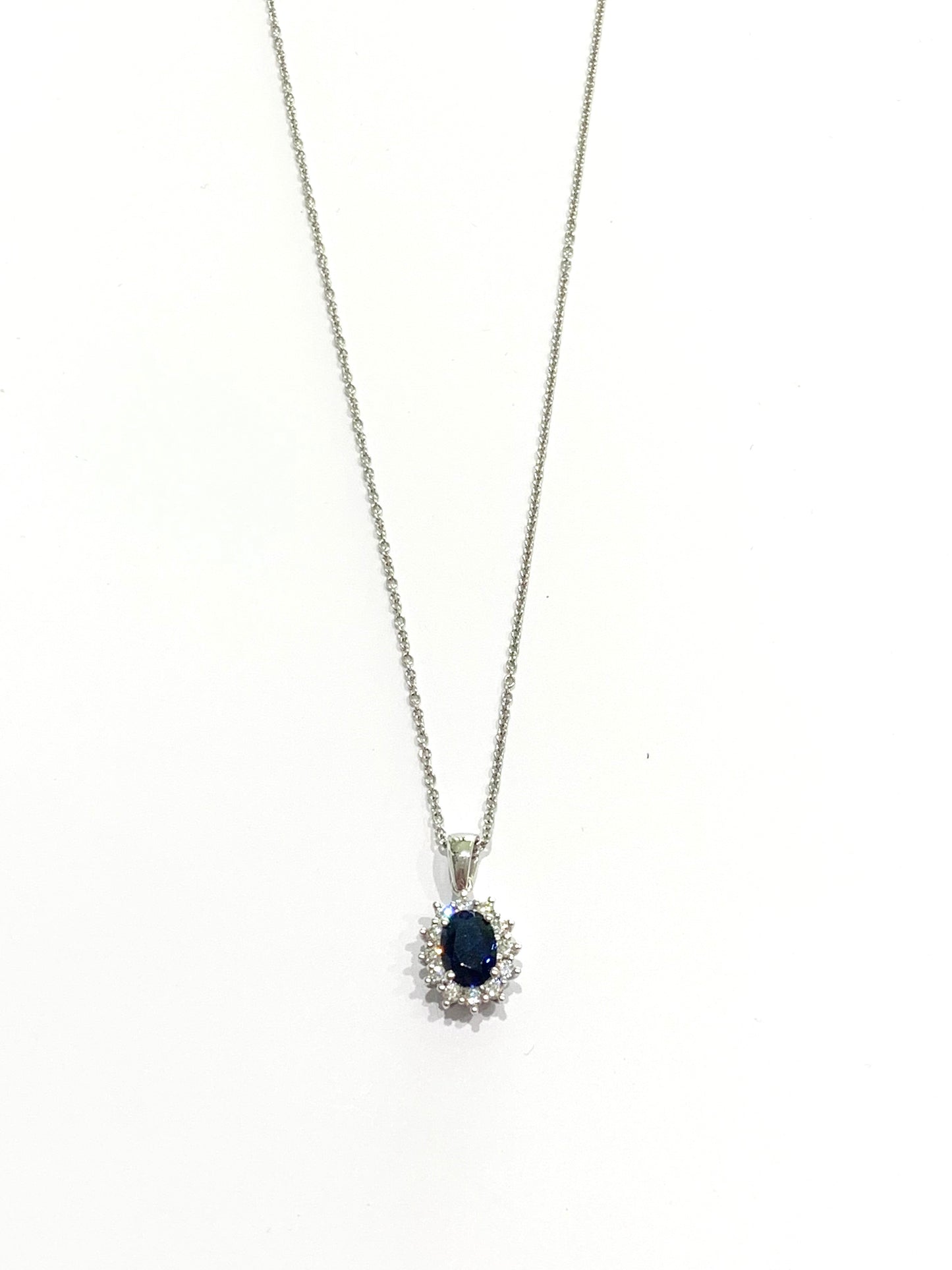 Collana in oro bianco 18kt con zircone colore zaffiro ovale  circondato da zirconi bianchi.

Lunghezza catena 45 cm.

Dimensioni ciondolo 1,6x0,8 cm incluso anellino.