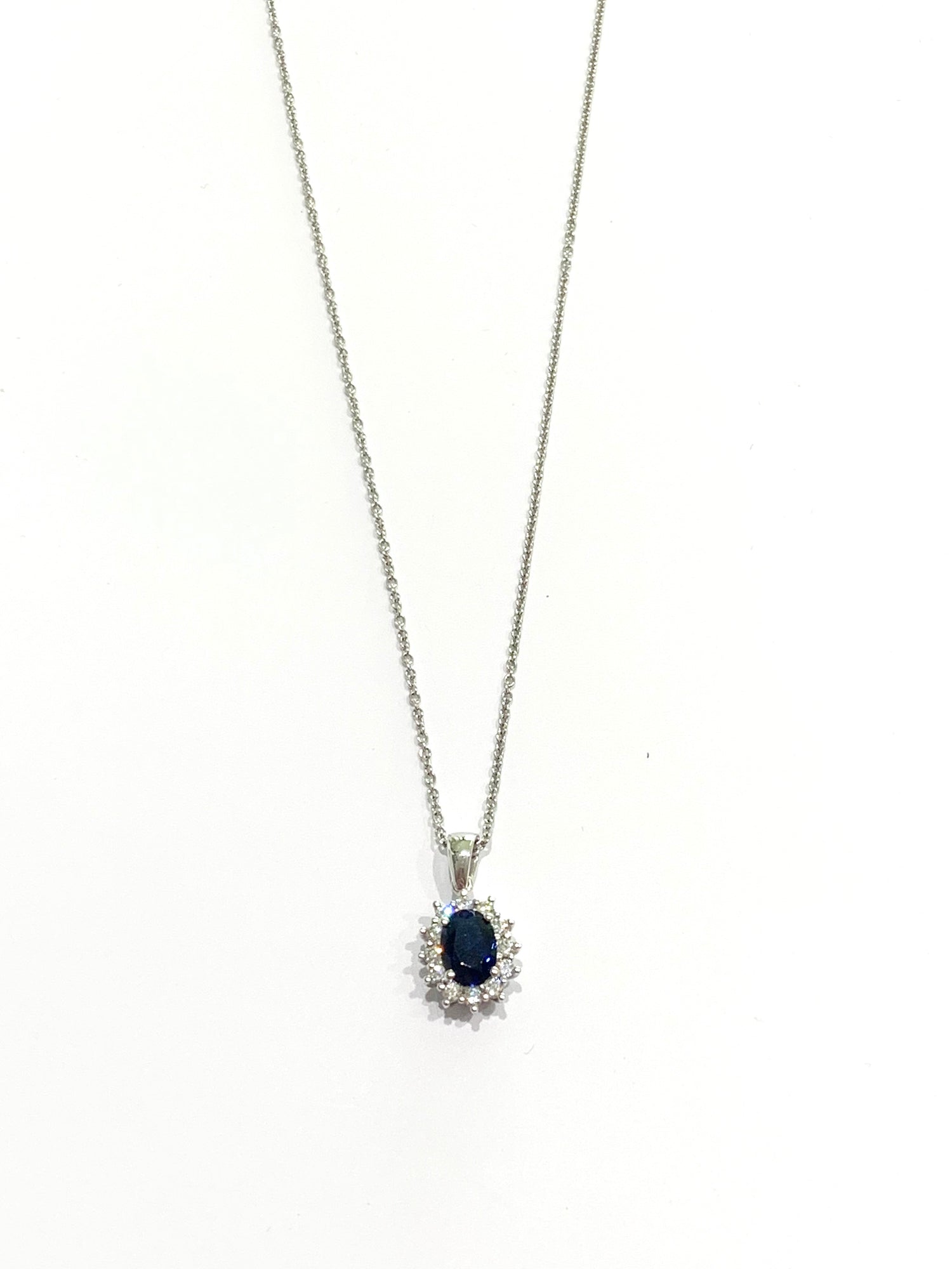 Collana in oro bianco 18kt con zircone colore zaffiro ovale  circondato da zirconi bianchi.

Lunghezza catena 45 cm.

Dimensioni ciondolo 1,6x0,8 cm incluso anellino.