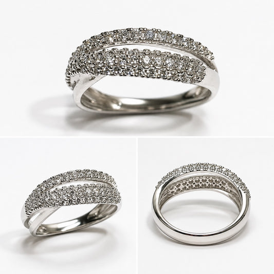 Anello in oro bianco 18kt con due fascette diagonali, una sottile composta da una fila di zirconi e una più larga impreziosita da tre file di zirconi.

Larghezza totale 0,5 cm.

Misura 14.