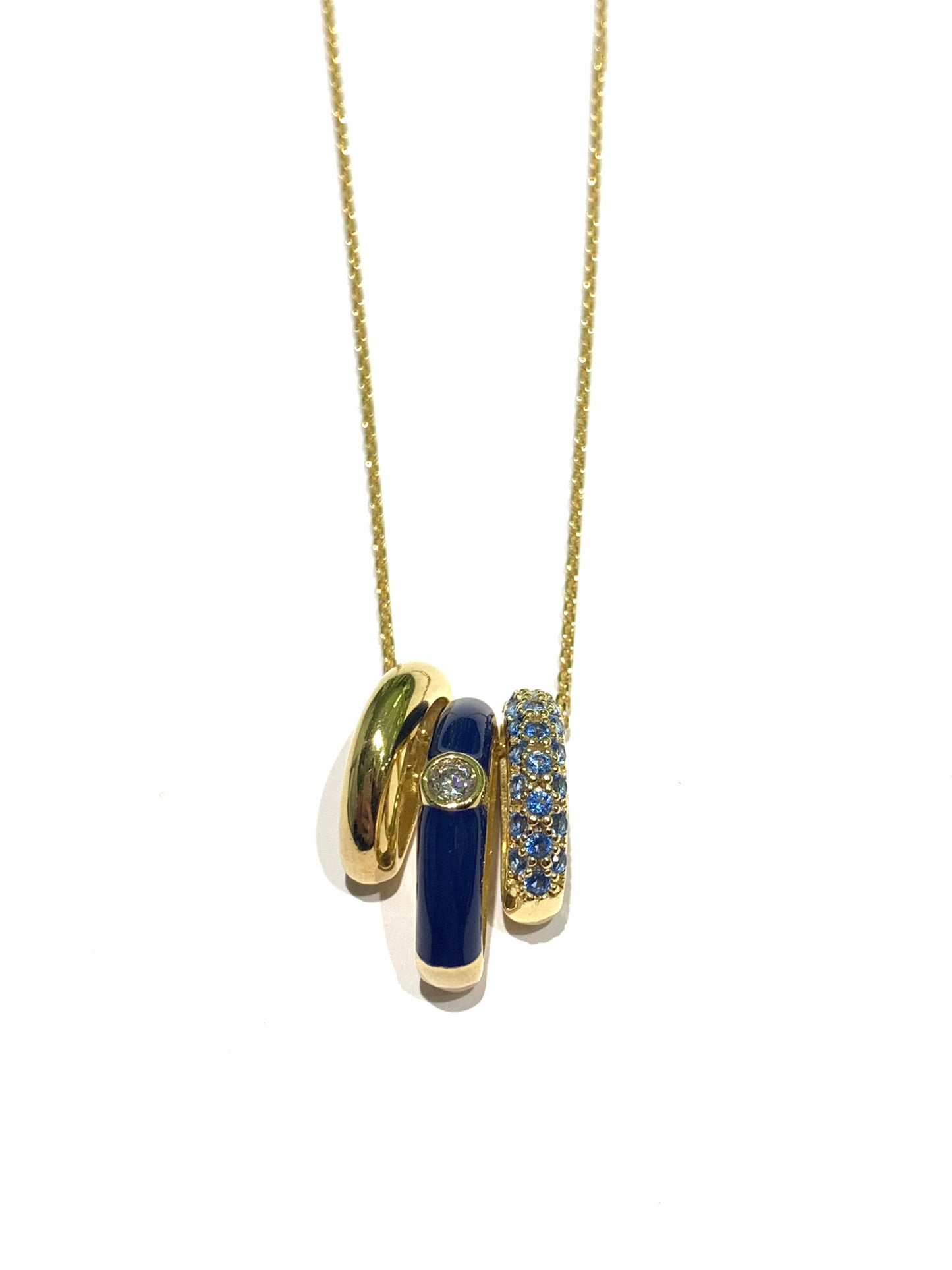 Collana in argento bagnata in oro giallo con ciondolo tondo. Esso é caratterizzato da tre strisce, di cui una smaltata blu, una impreziosita interamente da zirconi e una liscia in argento dorato.

Lunghezza catena regolabile a 40 cm oppure a 45 cm.

Dimensione ciondolo 1,3 cm.

Diametro interno del ciondolo 0,6 cm.

