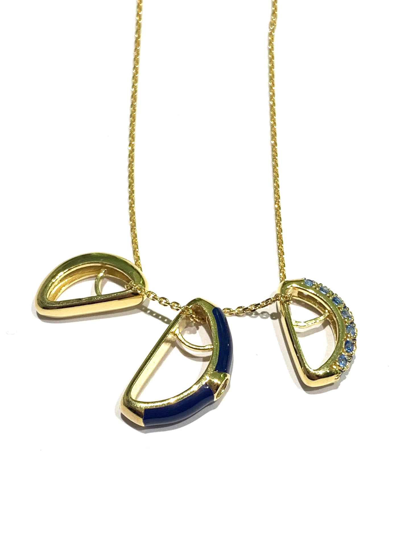 Collana in argento bagnata in oro giallo con ciondolo tondo. Esso é caratterizzato da tre strisce, di cui una smaltata blu, una impreziosita interamente da zirconi e una liscia in argento dorato.

Lunghezza catena regolabile a 40 cm oppure a 45 cm.

Dimensione ciondolo 1,3 cm.

Diametro interno del ciondolo 0,6 cm.
