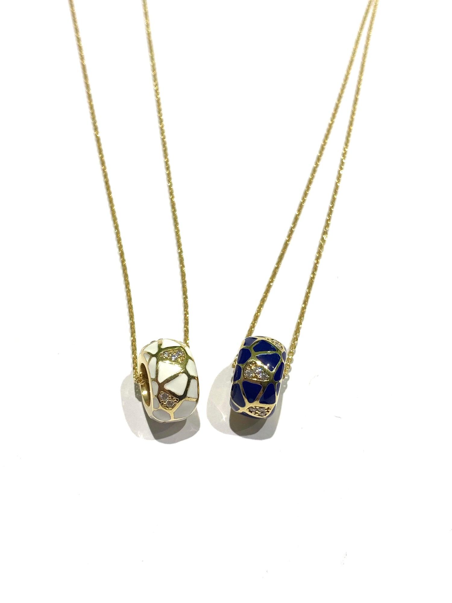 Collana in argento bagnata in oro giallo con ciondolo tondo ricoperto da smalto e zirconi.

Due colori disponibili: bianco o blu.

Lunghezza catena regolabile a 40 cm oppure a 45 cm.

Dimensione ciondolo 1,3 cm.

Diametro interno del ciondolo 0,6 cm.