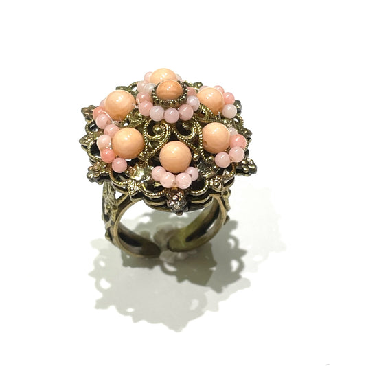 Anello in bijoux bagnato in oro con perline corallo.

Spessore 1 cm.

Larghezza totale 2,5 cm.