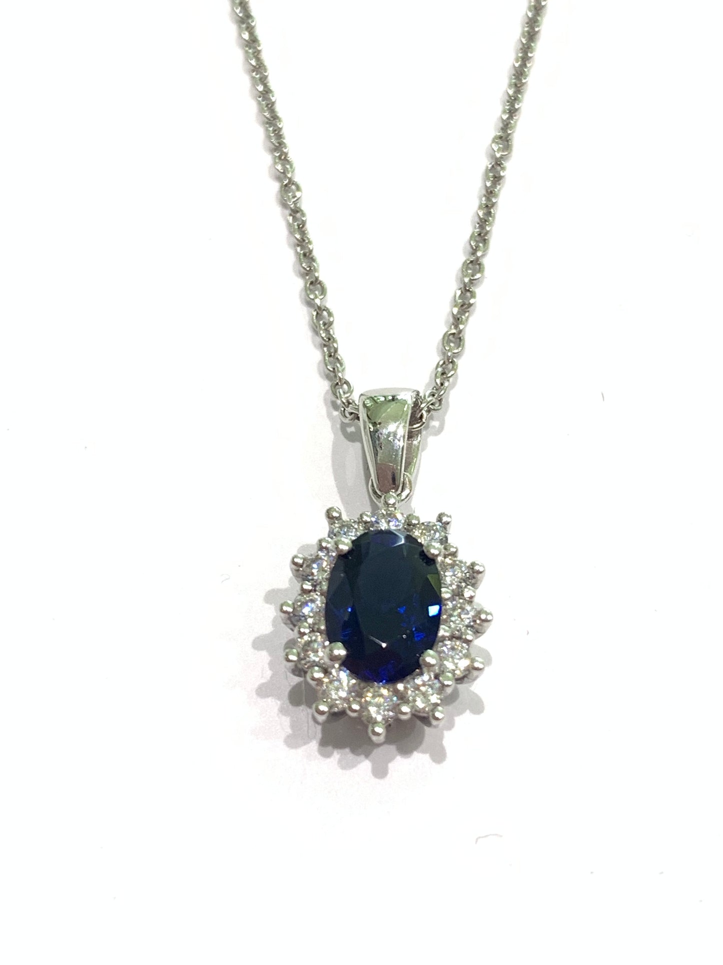 Collana in oro bianco 18kt con zircone colore zaffiro ovale  circondato da zirconi bianchi.

Lunghezza catena 45 cm.

Dimensioni ciondolo 1,6x0,8 cm incluso anellino.