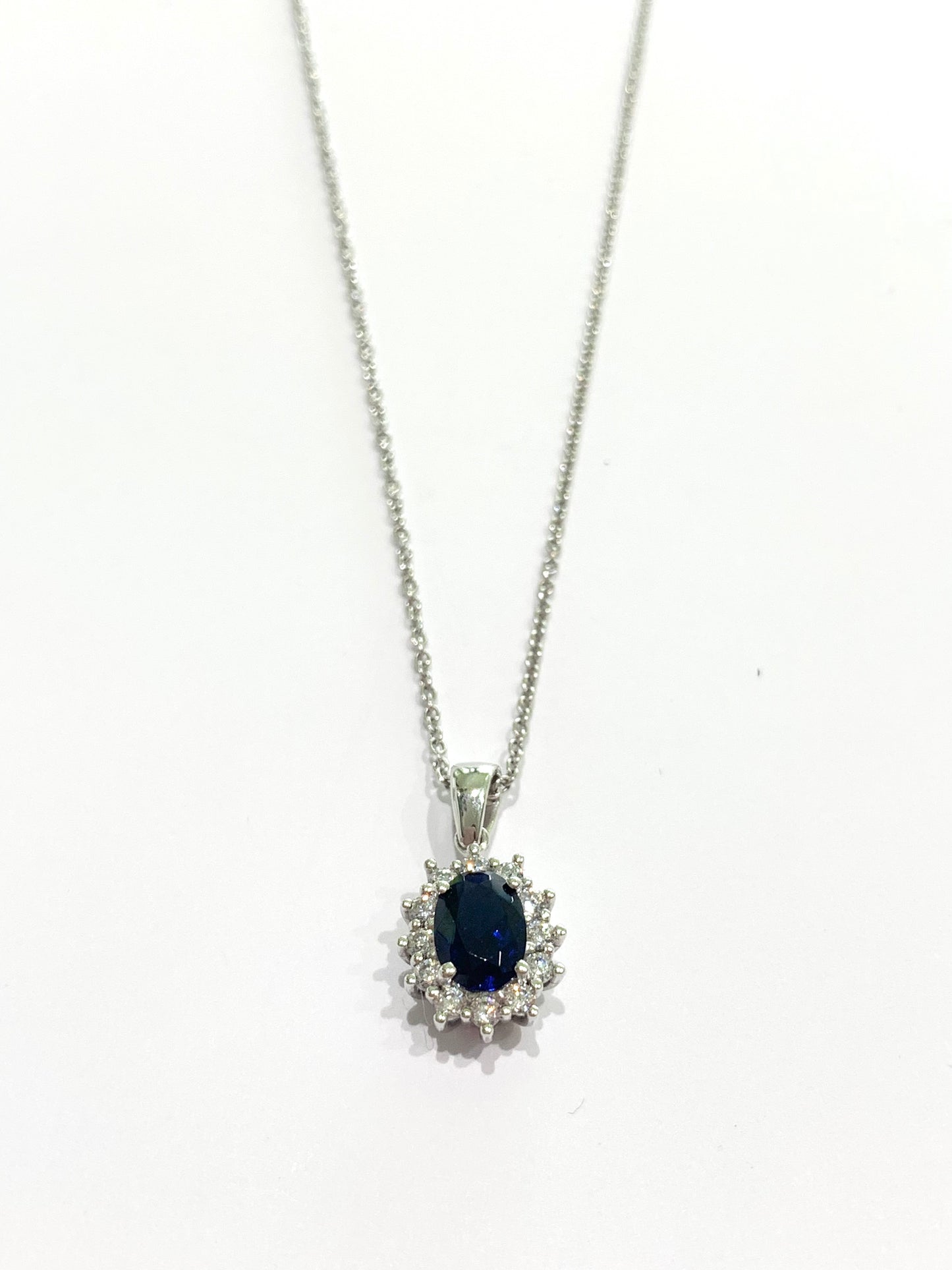 Collana in oro bianco 18kt con zircone colore zaffiro ovale  circondato da zirconi bianchi.

Lunghezza catena 45 cm.

Dimensioni ciondolo 1,6x0,8 cm incluso anellino.