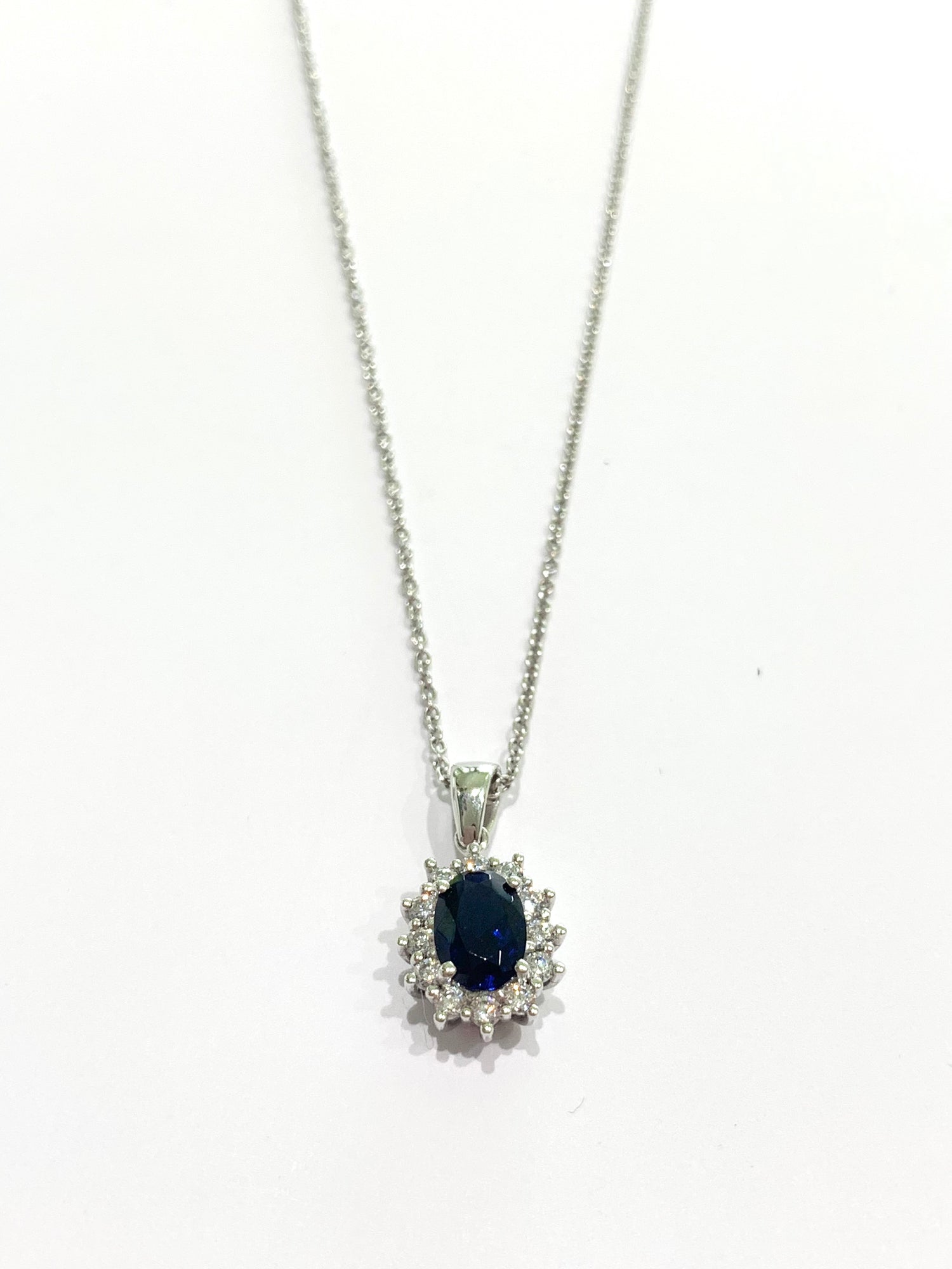Collana in oro bianco 18kt con zircone colore zaffiro ovale  circondato da zirconi bianchi.

Lunghezza catena 45 cm.

Dimensioni ciondolo 1,6x0,8 cm incluso anellino.