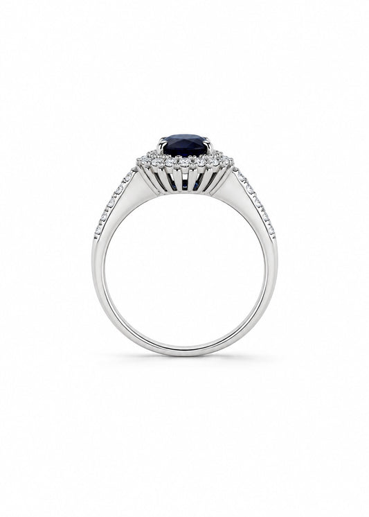 Anello in oro bianco 18kt con zircone centrale tondo colore zaffiro circondato da piccoli zirconi bianchi. 

Dimensione totale 1 cm.

Misura 14.