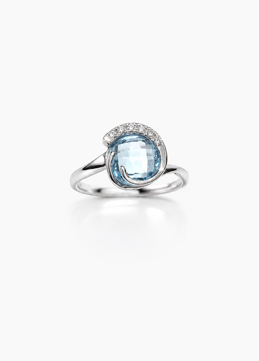Anello in oro bianco 18kt con zircone colore acquamarina tondo impreziosito da sei zirconi nella parte superiore.

Dimensione 1 cm.

Misura 15.