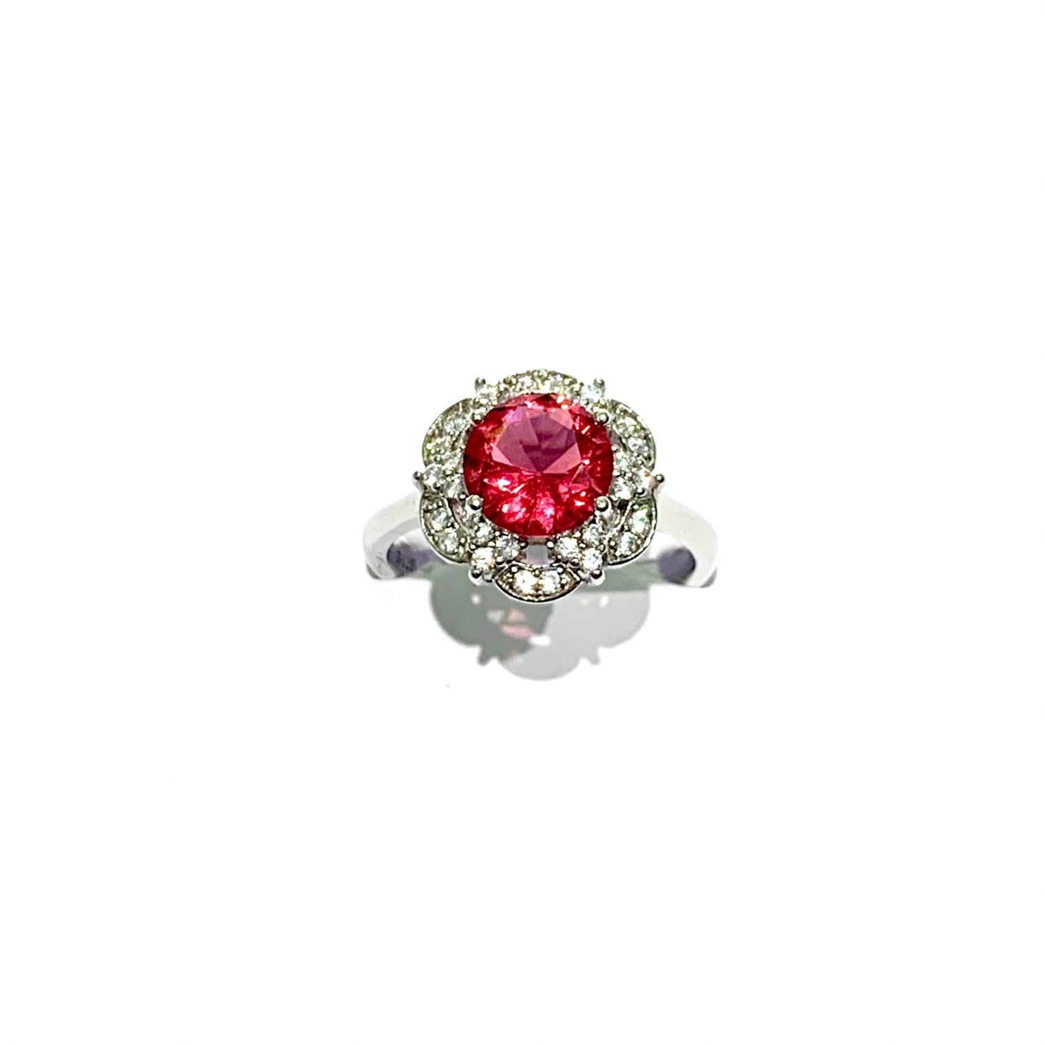 Anello in argento con zircone tondo colore rubino circondato da corolle ricoperte da piccoli zirconi bianchi.  Dimensione 1,2 cm.  Misura 15.