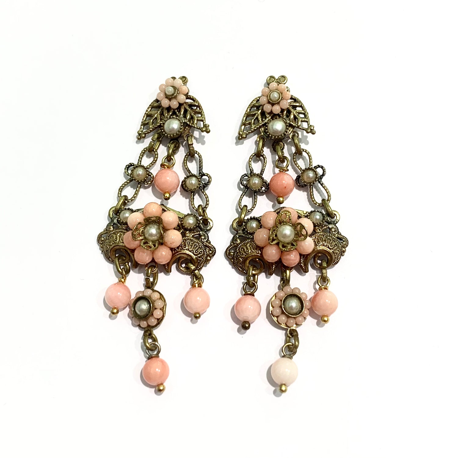 Orecchini pendenti in bijoux bagnati in oro giallo con perline color corallo rosa.  Lunghezza totale 6,5 cm.  Larghezza nella parte più ampia 3 cm.  Chiusura con farfalline.  Spedizione gratuita con confezione regalo. 