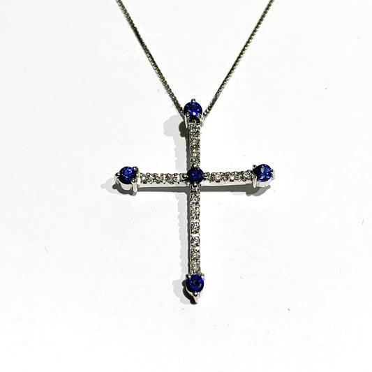 Collana in oro bianco 18kt con ciondolo a forma di croce ricoperta da diamanti e zaffiri. Lunghezza catena 42 cm. Caratura diamanti 0,08. Dimensione croce 2,7x2 cm. Spedizione gratuita con confezione regalo.