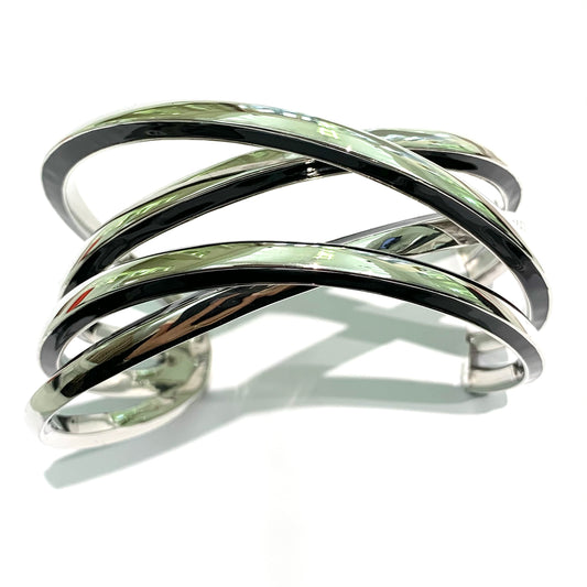 Bracciale rigido in argento quattro bracciali intrecciati con bordi smaltati neri. Circonferenza interna 21 cm, di cui 3 cm nella parte aperta. Spessore singolo bracciale 0,5 cm. Larghezza toale dei quattro bracciali 3 cm. Spedizione gratuita con confezione regalo.