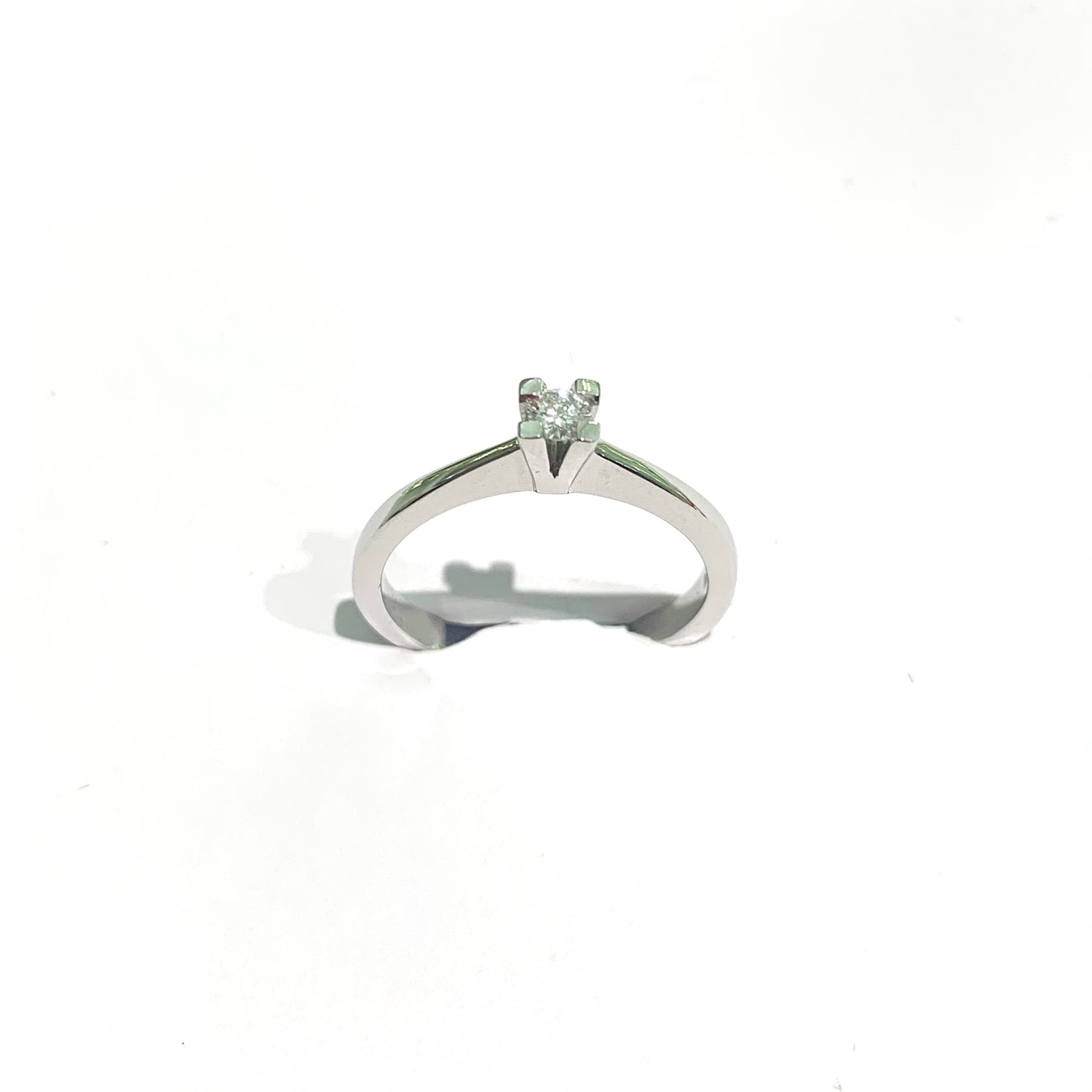 Anello in oro bianco 18kt con diamante solitario e quattro griffes.  Diamante 0,12 carati, dimensione 0,3 cm.  Misura 12.