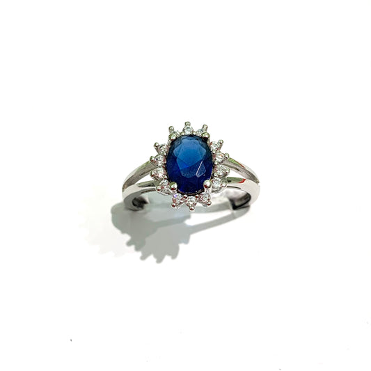 Anello in argento con zircone ovale colore zaffiro circondato da zirconi bianchi. Disponibili in due grandezze: Zaffiro piccolo 0,6 cm, misura anello 14. Zaffiro grande di 0,8 cm, misura anello 12.