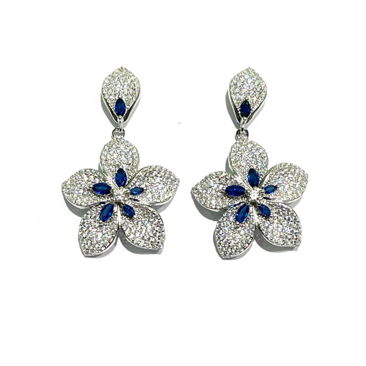 Orecchini in argento con fiori pendenti ricoperti da zirconi bianchi e blu.  Dimensione fiore 2 cm.  Lunghezza totale 3,5 cm.  Chiusura con farfalline.