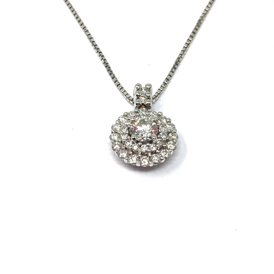 Collana in oro bianco 18kt con diamante solitario circondato da altri diamanti. Lunghezza catena 42 cm. Dimensione ciondolo 1,5 cm di altezza inclusa piccola barretta. Caratura solitario centrale 0,31, circondato da diamanti di 0,47 carati. Spedizione gratuita con confezione regalo.