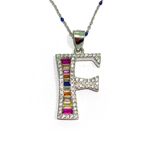 Collana in argento con iniziale F coperta da zirconi colorati e con la catena impreziosita da piccoli pallini blu. Lunghezza catena regolabile da 38 cm a 43 cm. Dimensioni ciondolo 2x1 cm. Spedizione gratuita con confezione regalo.