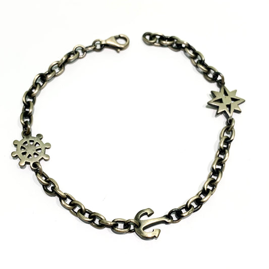 Bracciale per uomo in argento brunito con ancora, timone e rosa dei venti. Lunghezza regolabile da 18 cm a 21 cm. Spessore bracciale 0,4 cm. Larghezza inserti 1 cm. Spedizione gratuita con confezione regalo.