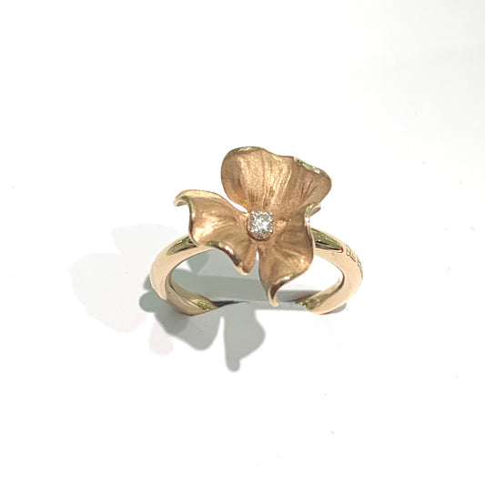 Anello in oro giallo 18kt a forma di fiore con tre petali e diamante al centro. Diamante di 0,10 carati. Marchio Annamaria Cammilli. Dimensioni fiore 1 cm. Misura 15.