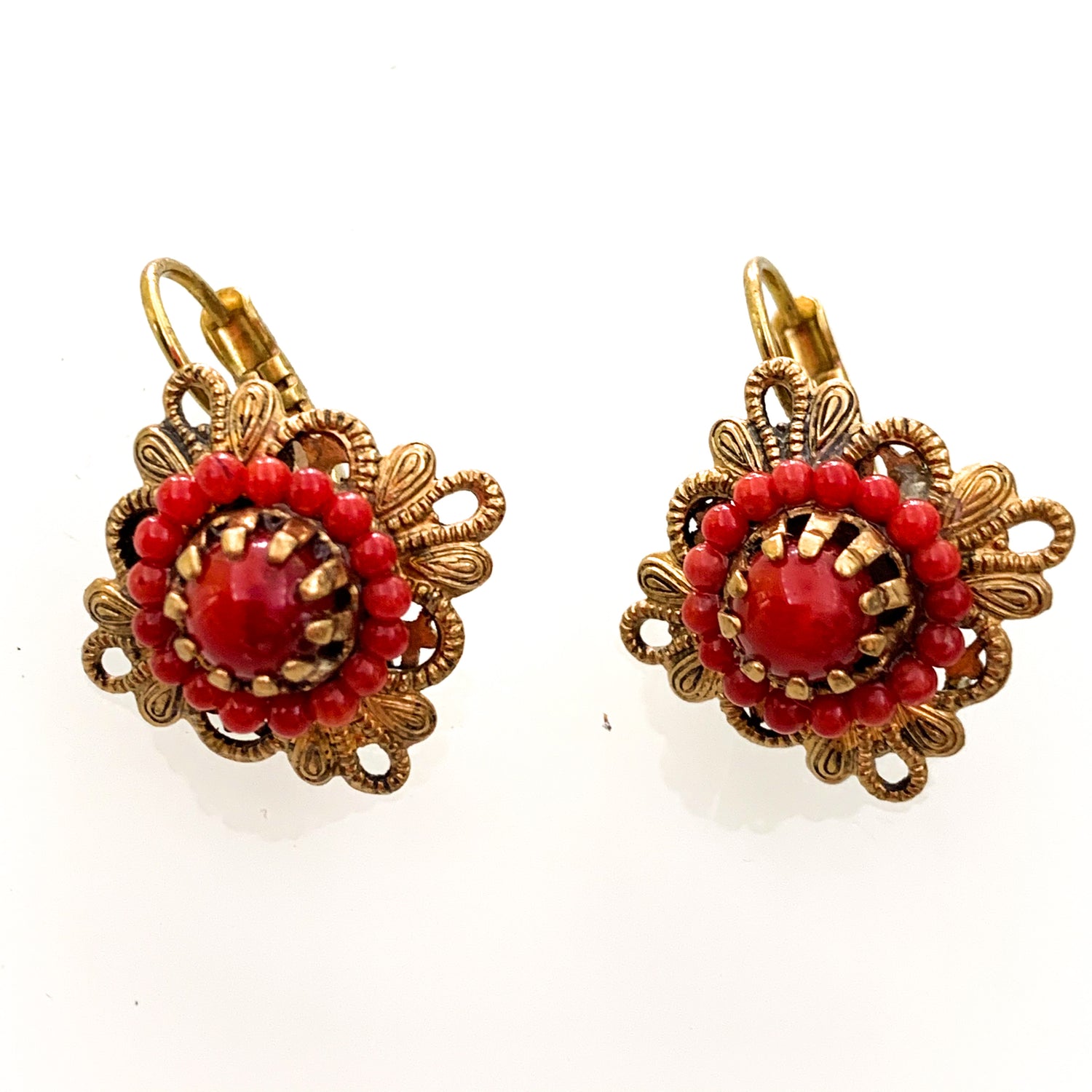 Orecchini in bijoux bagnati in oro a forma di rombo con coralli rossi.  Dimensione 2 cm.  Chiusura a monachella.  Spedizione gratuita con confezione regalo.